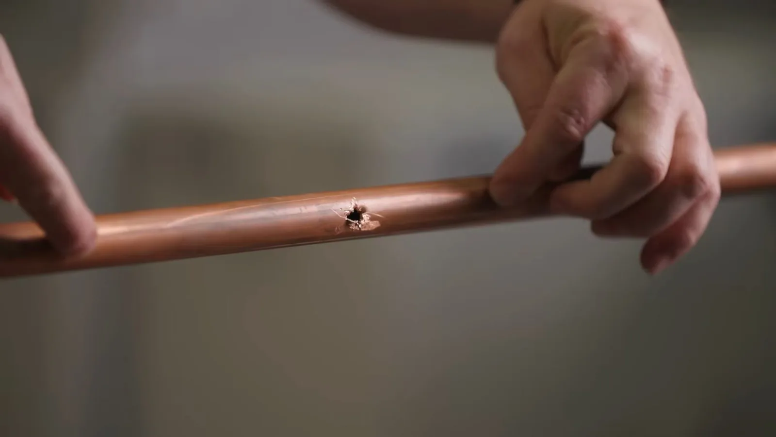 Copper pipe repair section in hand, photographed during repiping work in Chino Valley, AZ.