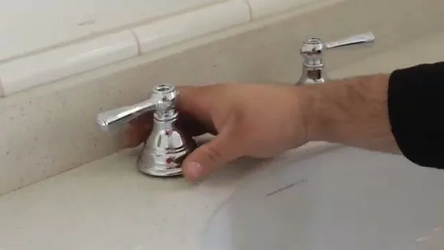 Disconnecting toilet tank bolts, photographed during toilet repair work in Chino Valley, AZ.