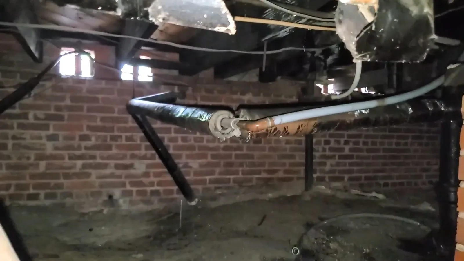 Exposed old plumbing below crawlspace, during crawlspace plumbing work for a Williamson Valley, AZ property.