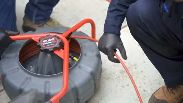 Feeding inspection camera into sewer cleanout, seen during sewer line service in Chino Valley, AZ.