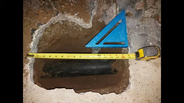 Measuring basement slab opening for bathroom drain, during slab leak work for a Chino Valley, AZ property.