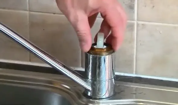 Reinstalling kitchen faucet control cap, photographed during faucet repair work in Chino Valley, AZ.