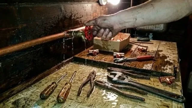 Repairing copper pipe in cold workshop, seen during repiping service in Chino Valley, AZ.