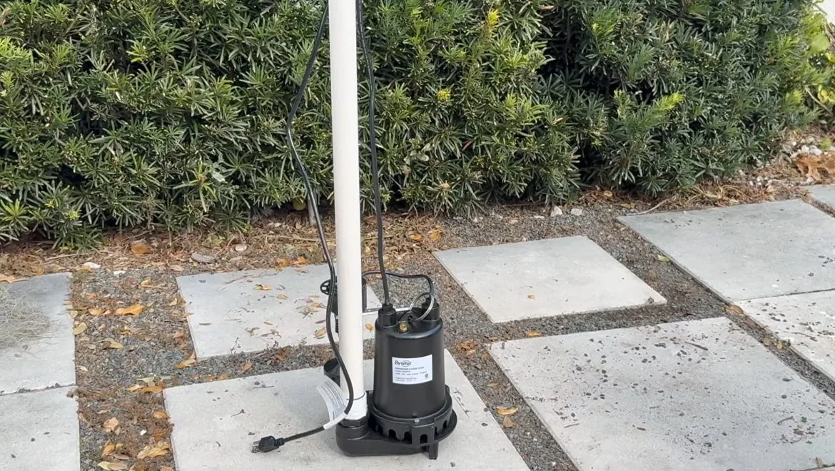 Sump pump discharge outside house, seen during sump pump service in Chino Valley, AZ.