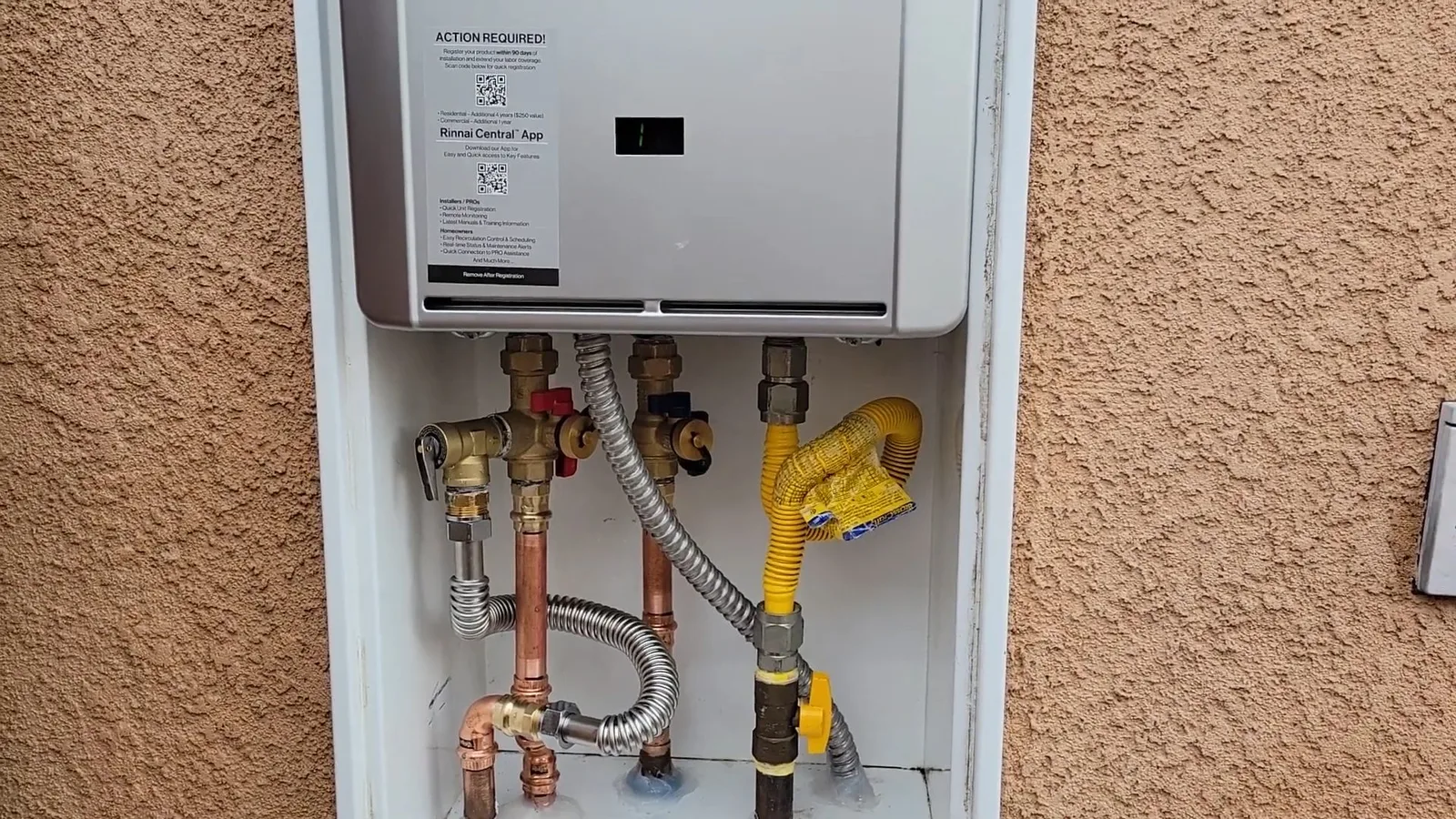 Tankless water heater mounted on stucco wall, during tankless water heater work for a Chino Valley, AZ property.