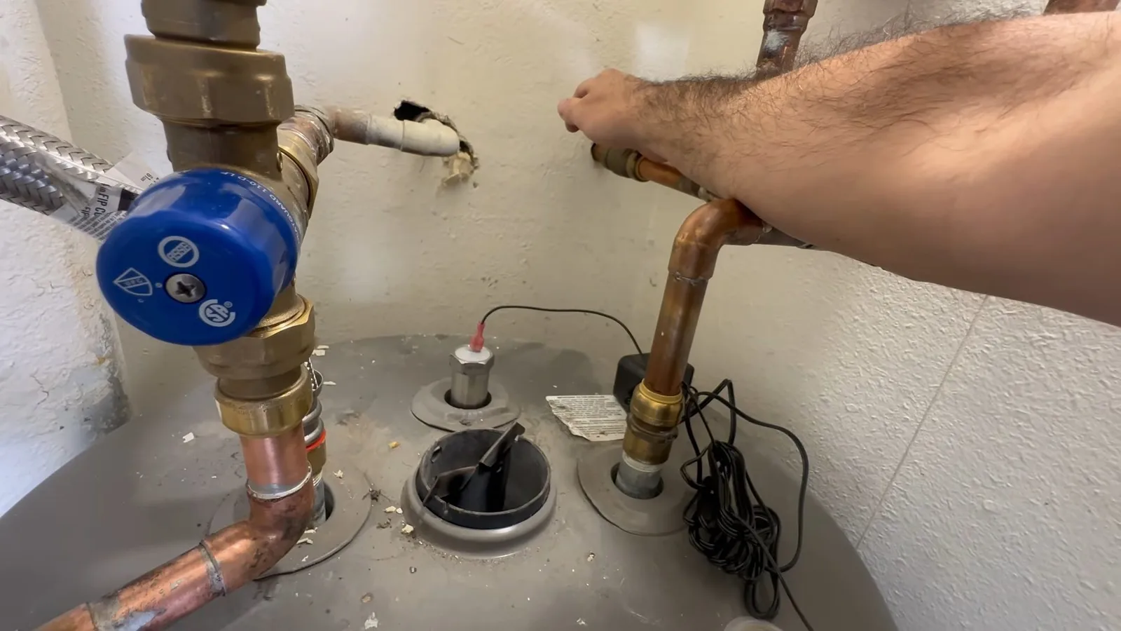 Technician inspecting water heater anode, during a water heater call in Chino Valley, AZ.