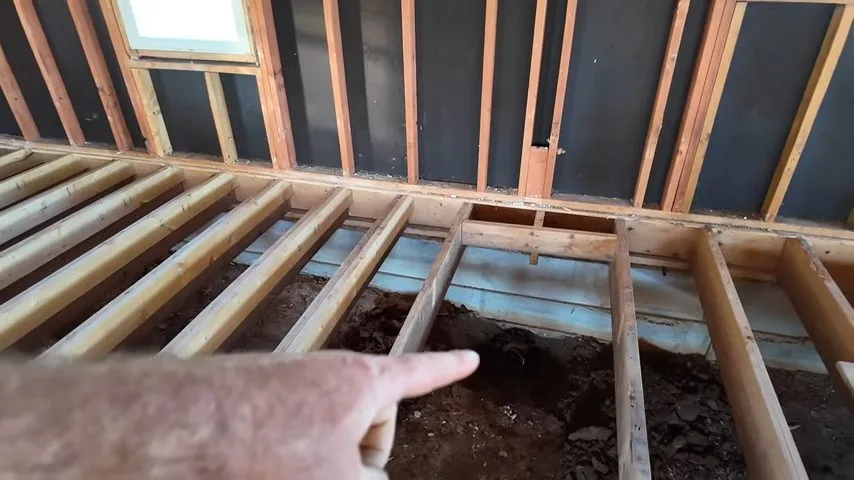 Wood joists exposed for septic pipe work, during a plumbing call in Chino Valley, AZ.