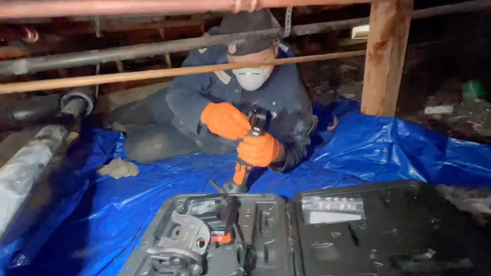 Workers repairing leaking crawlspace pipe, seen during crawlspace plumbing service in Chino Valley, AZ.